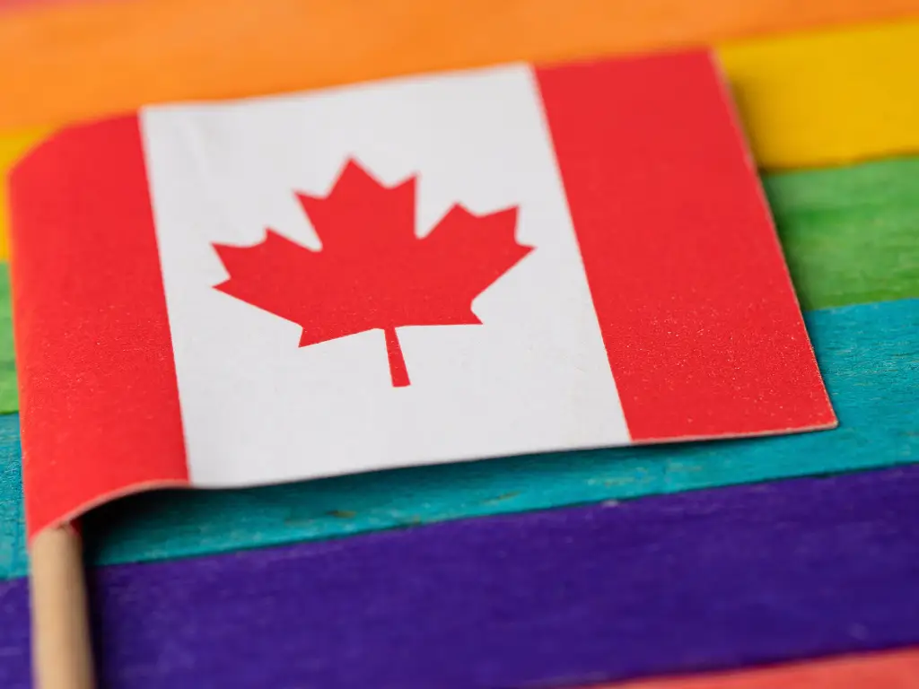 Bandera de Canadá sobre fondo arcoíris, símbolo del movimiento social LGBT