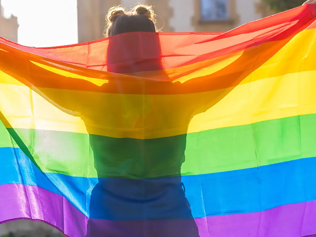 Mujer levanta la bandera del orgullo gay